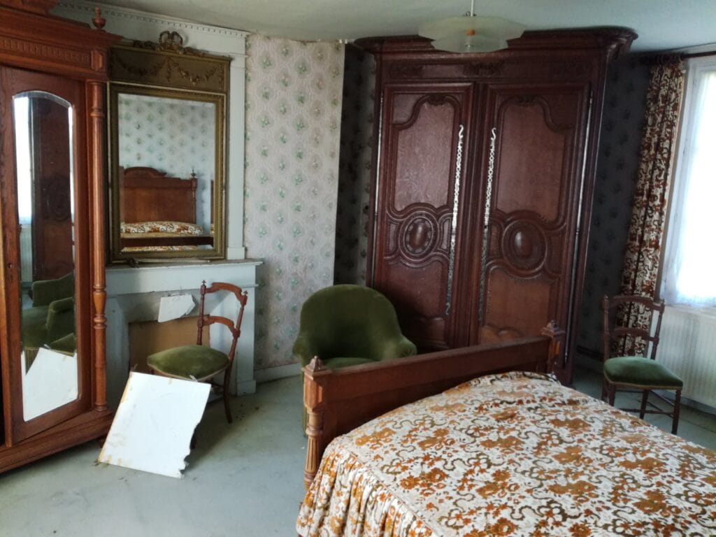armoire normande et meuble ancien dans une chambre avant débarras